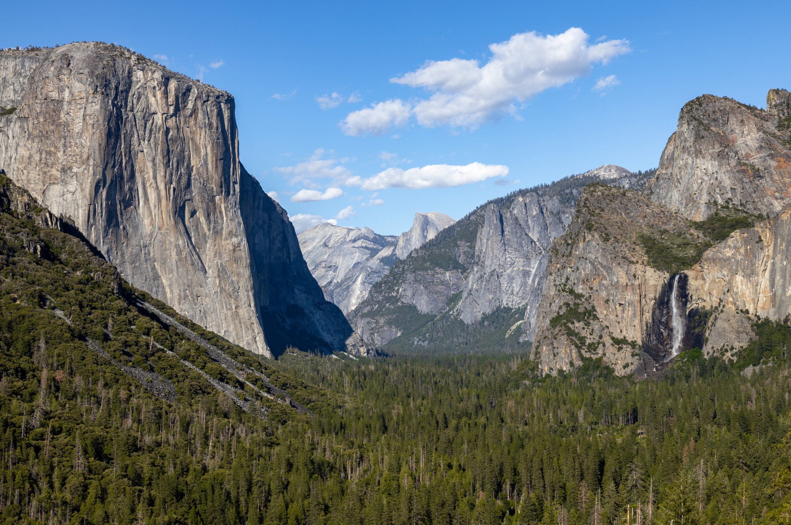 Yosemite Valley framed by granite cliffs, with El Capitan on the left, Half Dome in the distance and Bridalveil Fall on the right.